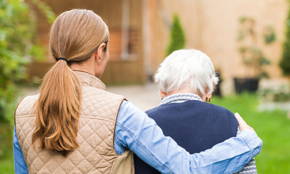 A family member sitting with an elderly loved one at home in Alabama