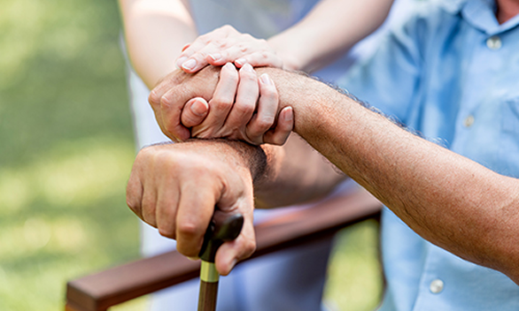 A caregiver and elderly woman smiling together at home in Central Alabama